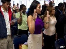 People take the oath of allegiance at a naturalization ceremony in New York