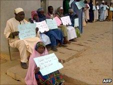 Nigerian parents and their deaf and dumb children holding placards, explaining their grievances against Pfizer, outside a court in Kano (January 2008)