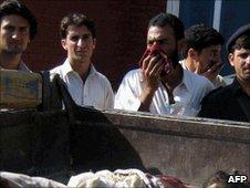 Pakistani residents look at the bodies of militants killed in a military operation in Lower Dir on July 6, 2010