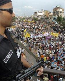 A Bangladesh Rapid Action Battalion officer watches an opposition rally in Dhaka in July 2006