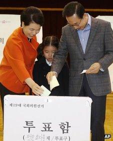 South Korean President Lee Myung-bak, right, and his wife Kim Yoon-ok cast their ballots in the parliamentary elections as their unidentified granddaughter looks on at a polling station in Seoul, South Korea, on 11 April, 2012