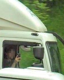 A motorist taking a picture on a mobile phone