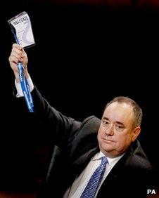 Alex Salmond holds aloft his voting card