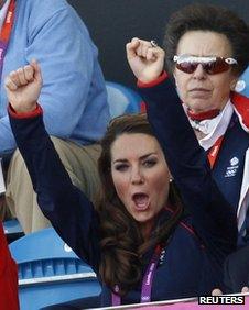 The Duchess of Cambridge cheers while Princess Anne sits impassively in the row behind her at a stadium