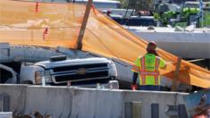 A worker stands near a truck beneath a collapsed pedestrian bridge at Florida International University in Miami, Florida, U.S., March 16, 2018.
