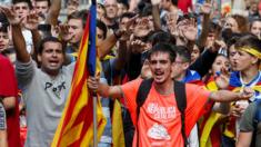 Students raise their arms during a demonstration marking the first anniversary of Catalonia's independence referendum.
