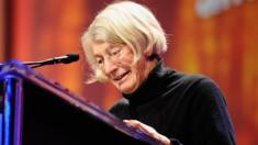 Poet Mary Oliver speaks from a lectern, pictured in October 2010 in Long Beach, California