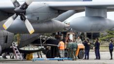 Personal militar de Chile descarga los restos encontrados del tren de aterrizaje del avión Hércules C-130.