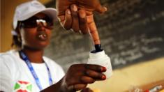 A person dips their finger in ink after voting in Burundi