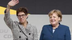 The elected chairwoman Annegret Kramp-Karrenbauer (L) waves next to German Chancellor Angela Merkel