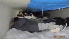 The migrants laying on a sheet of ice inside the truck