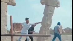 Screengrab from a viral video showing three men shoving a pillar in Hampi