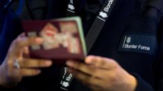 File image of a Border Force officer checking passports at Heathrow Airport