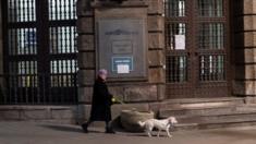 A woman walks her dog during a curfew imposed to prevent the spread of coronavirus disease in Belgrade