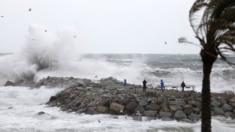 People look at huge waves battering a beach in Barcelona, Spain. Photo: 20 January 2020
