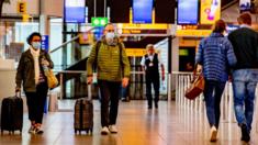 Travellers wearing face masks as a precaution, at KLM side at the Schiphol airport during the covid - 19 pandemic.