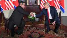 US President Donald Trump (R) shakes hands with North Korea's leader Kim Jong-un (L) as they sit down for their historic US-North Korea summit