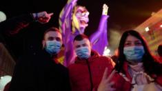 Revellers wear masks to protect themselves from the virus as they attend the Nice carnival on 25 February 2020