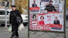 People walk past election posters in Yerevan on 6 December, 2018, days before the 9 December early parliamentary elections