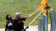 Paul Kagame and Jean-Claude Juncker help light a remembrance flame