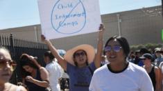 A protester holds up a banner saying 'No child internment camps' outside an immigration detention centre in El Paso, Texas, 19 June 2018