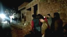 Residents and police outside the building where a man has held hostages in Farrukhabad