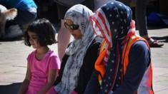 Muslim women pray before participating in the 