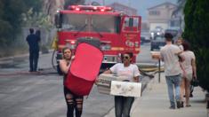 Residents carry belongings in Lake Elsinore, California, south-east of Los Angeles, on August 10, 2018