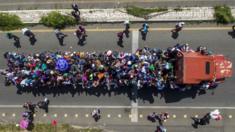 Image shows an eerial view of Honduran migrants onboard a truck as they take part in a caravan heading to the US