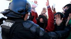 Protesters confront a French gendarme at the AP-7 highway at the Spanish-French border in La Jonquera northern Spain, 11 November 2019
