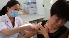 Una mujer china recibe una vacuna.