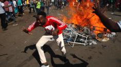 Supporters of the opposition MDC Alliance react as they block a street in Harare, Zimbabwe - 1 August 2018