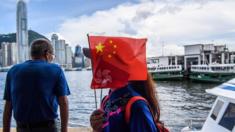 A member of a local community group holds Chinese and Hong Kong flags