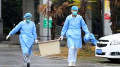 Medical staff carry a box as they walk at the Jinyintan hospital, where the patients with pneumonia caused by the new strain of coronavirus are being treated, in Wuhan, Hubei province