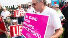 A supporter of Planned Parenthood walks past anti-abortion demonstrators in Missouri in May 2019