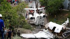 A crane lifts the wreckage of a Gulfstream G200 aircraft that skidded off the runway during landing at Toncontin International Airport in Tegucigalpa, Honduras