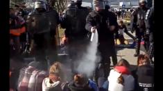 French riot police try to evacuate climate change activists blocking a road at Chambéry airport