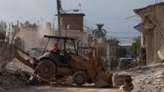 Maquinaria pesada remueve los escombros en Jojutla frente a una casa en pie