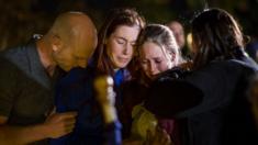 People hug and cry during a vigil to pay tribute to the victims of a shooting in Thousand Oaks, California