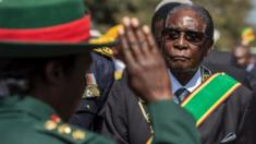 Zimbabwe President Robert Mugabe (R) inspects a guard of honour during official Heroes Day commemorations held at National Heroes Acre in Zimbabwe on August 14, 2017.