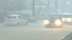 A car drives through a flooded street in Japan
