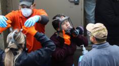 Members of a Servpro cleaning crew take off their protective gears as they exit the Life Care Center of Kirkland, the Seattle-area nursing home at the epicenter of one of the biggest coronavirus outbreaks in the United States, in Kirkland, Washington, U.S