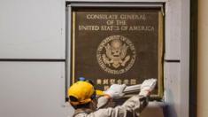 A man attempts to remove the diplomatic plaque form a wall of the US consulate in Chengdu, China. Photo: 26 July 2020