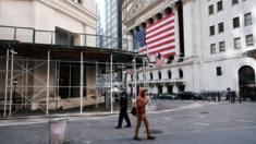 A man walks down an almost empty Wall Street