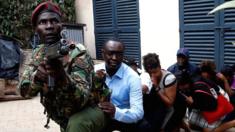 Kenyan police special forces man with red beret and gun, with civilians behind him