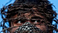 A masked Kashmiri man with his head covered with barbed wire attends a protest after Friday prayers during restrictions following the scrapping of the special constitutional status for Kashmir by the Indian government, in Srinagar, October 11, 2019