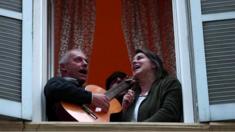 Man and woman singing at window