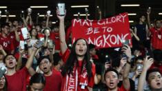 Football fans hold up their phones and shout during a protest at the end of the World Cup qualifying match between Hong Kong and Iran at Hong Kong Stadium on September 10, 2019