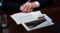 US President Donald Trump sits with his notes and a picture of a wall during a meeting about border security in the Cabinet Room of the White House January 11, 2019 in Washington, DC.