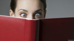 Девушка, читающая книгу в красной обложке